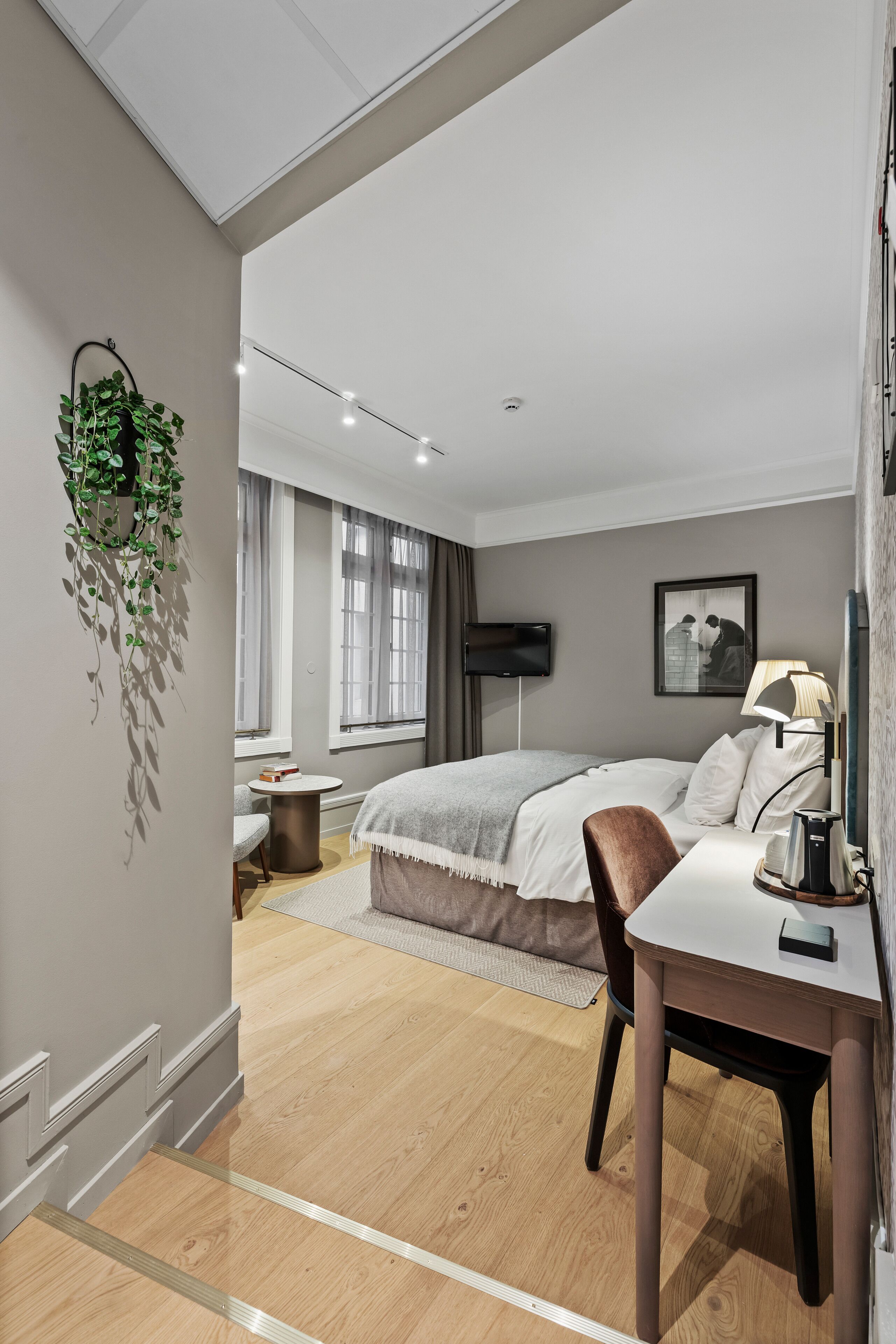 Une chambre à coucher moderne avec un lit, une table de chevet et un bureau avec une chaise.