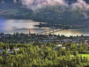 A town with a bridge over a river, surrounded by dense forests and houses. - Hotel Breiseth (Lillehammer)