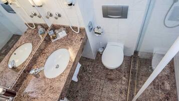 A bathroom with two sinks, a toilet, and a shower.