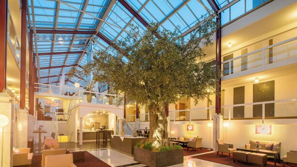 A spacious lobby with a large tree, comfortable seating, a staircase, and a modern design. - Best Western Plus Hotel Fellbach-Stuttgart (Fellbach)