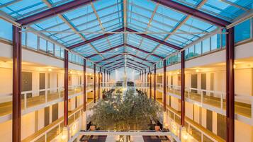 Un vaste atrium doté d’un plafond en verre, de plusieurs niveaux et d’un jardin intérieur central.