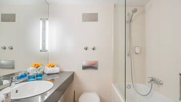 Une salle de bain moderne équipée d’un lavabo, de toilettes et d’une douche.