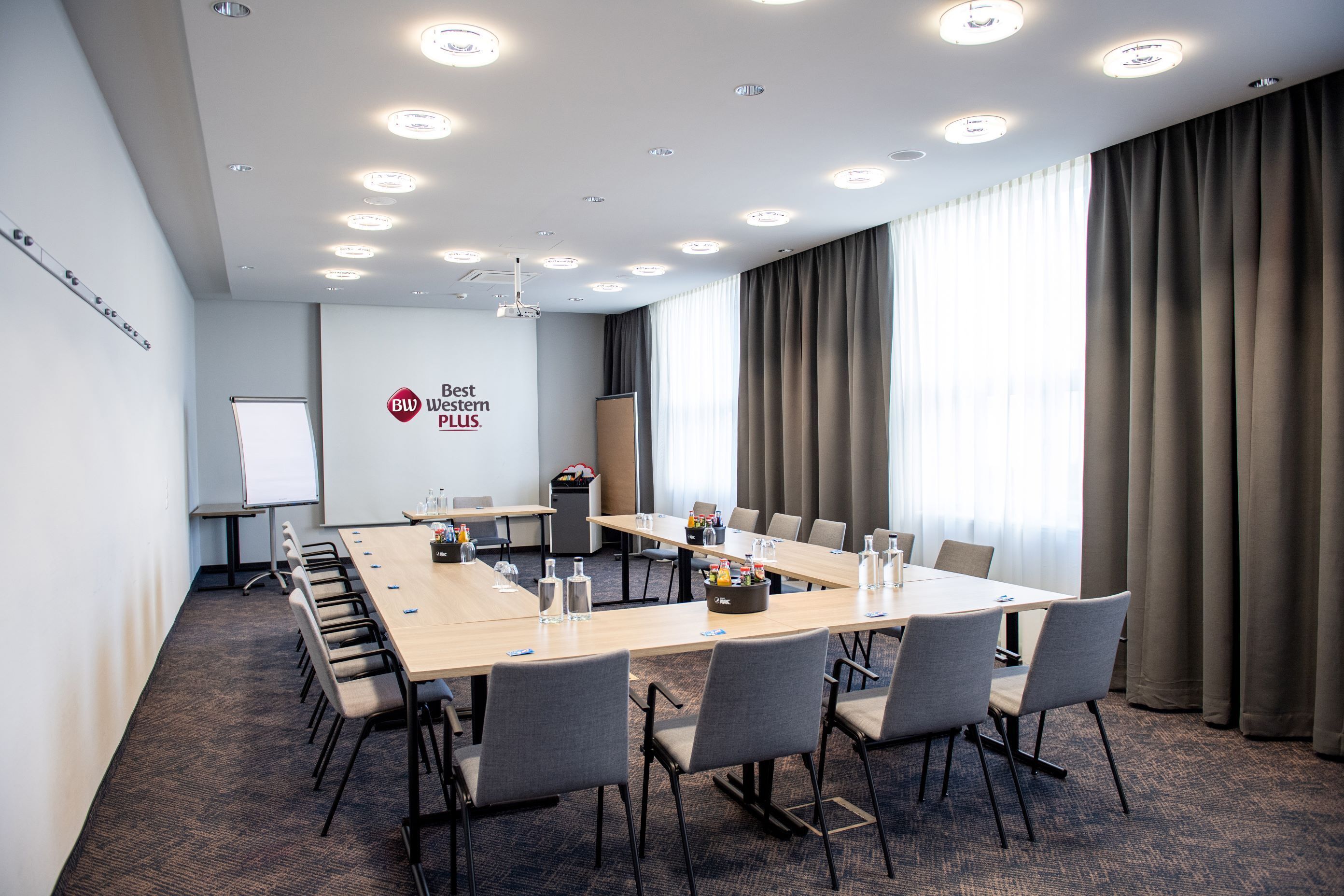 A conference room with a long table, chairs, a whiteboard, and a projector.