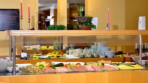A buffet counter with various food items, including fruits, vegetables, and meats. - Hotel am Park Lüneburger Heide (Hodenhagen)