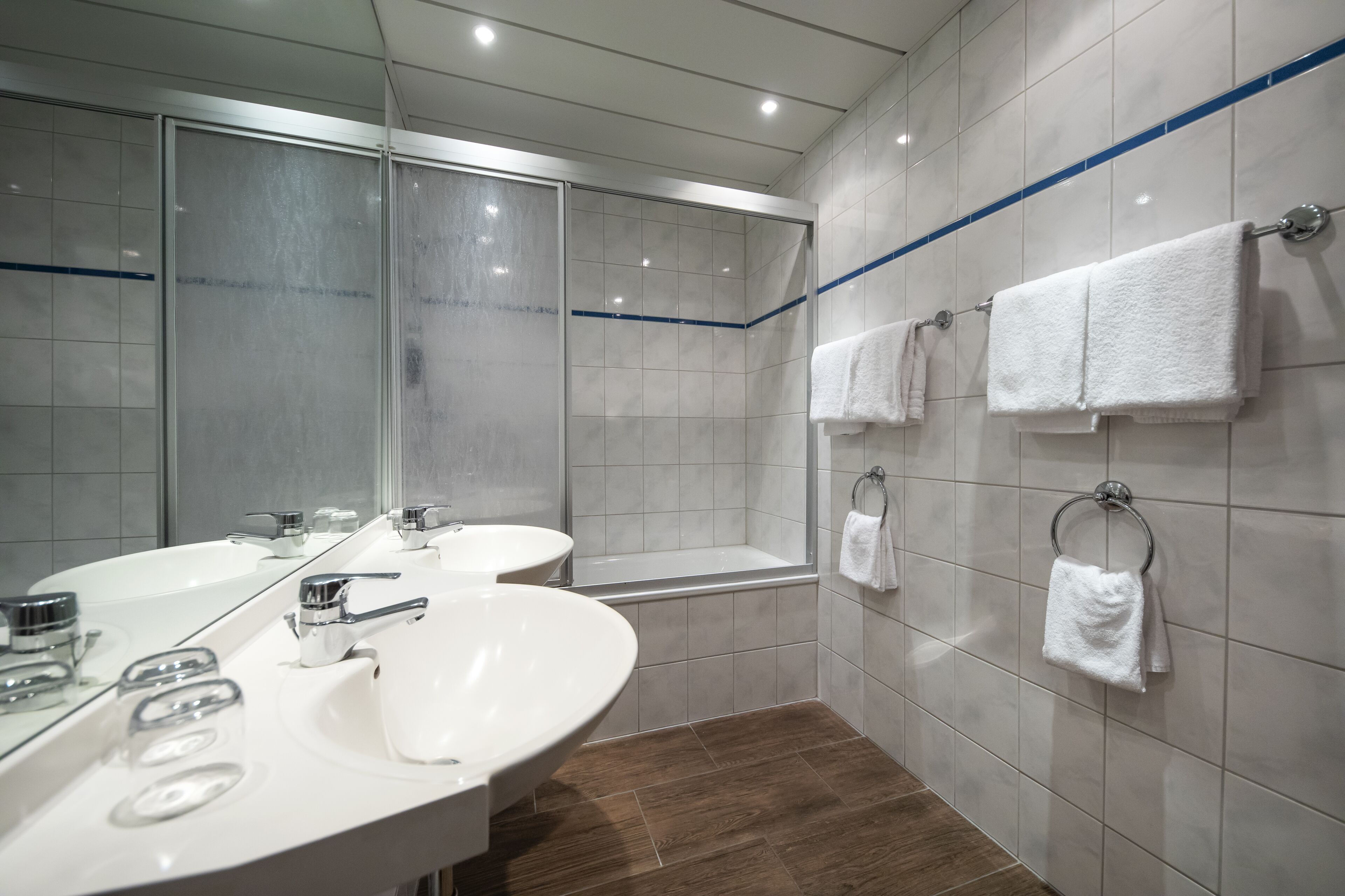 Un baño moderno con dos lavamanos, ducha y bañera.