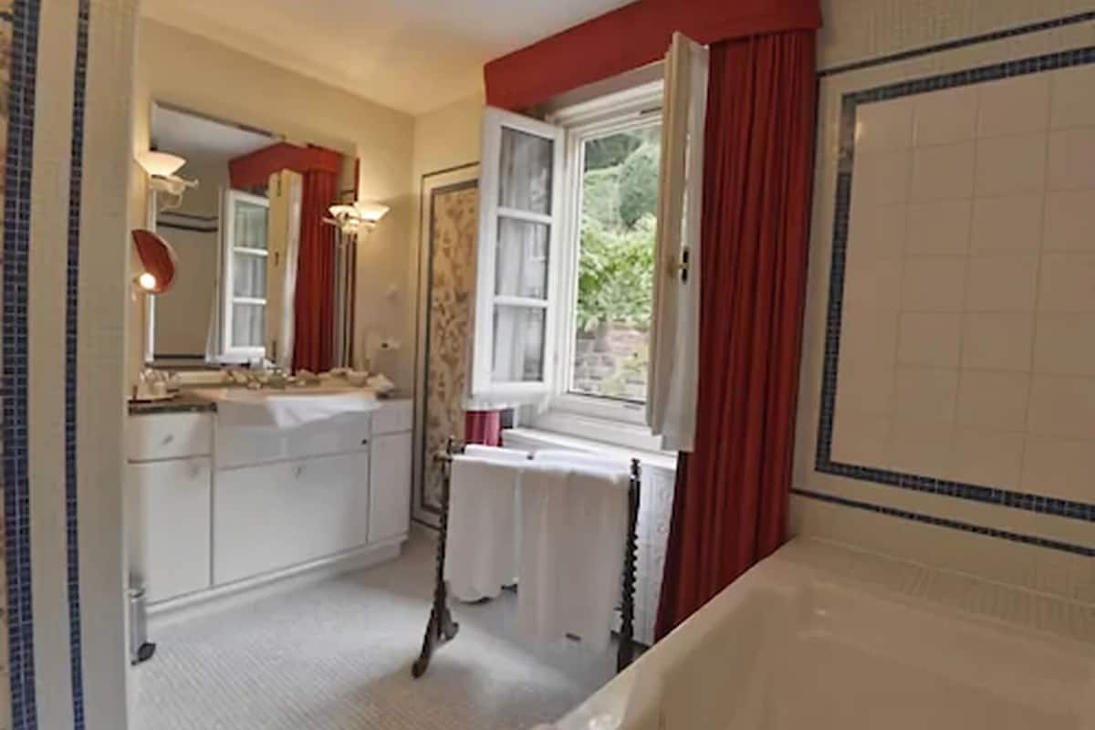 deluxe suite | bathroom | combined shower/bathtub, hydromassage showerhead, hair dryer, towels
