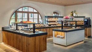 Une cuisine moderne avec des plans de travail en bois, un îlot central et une grande fenêtre.