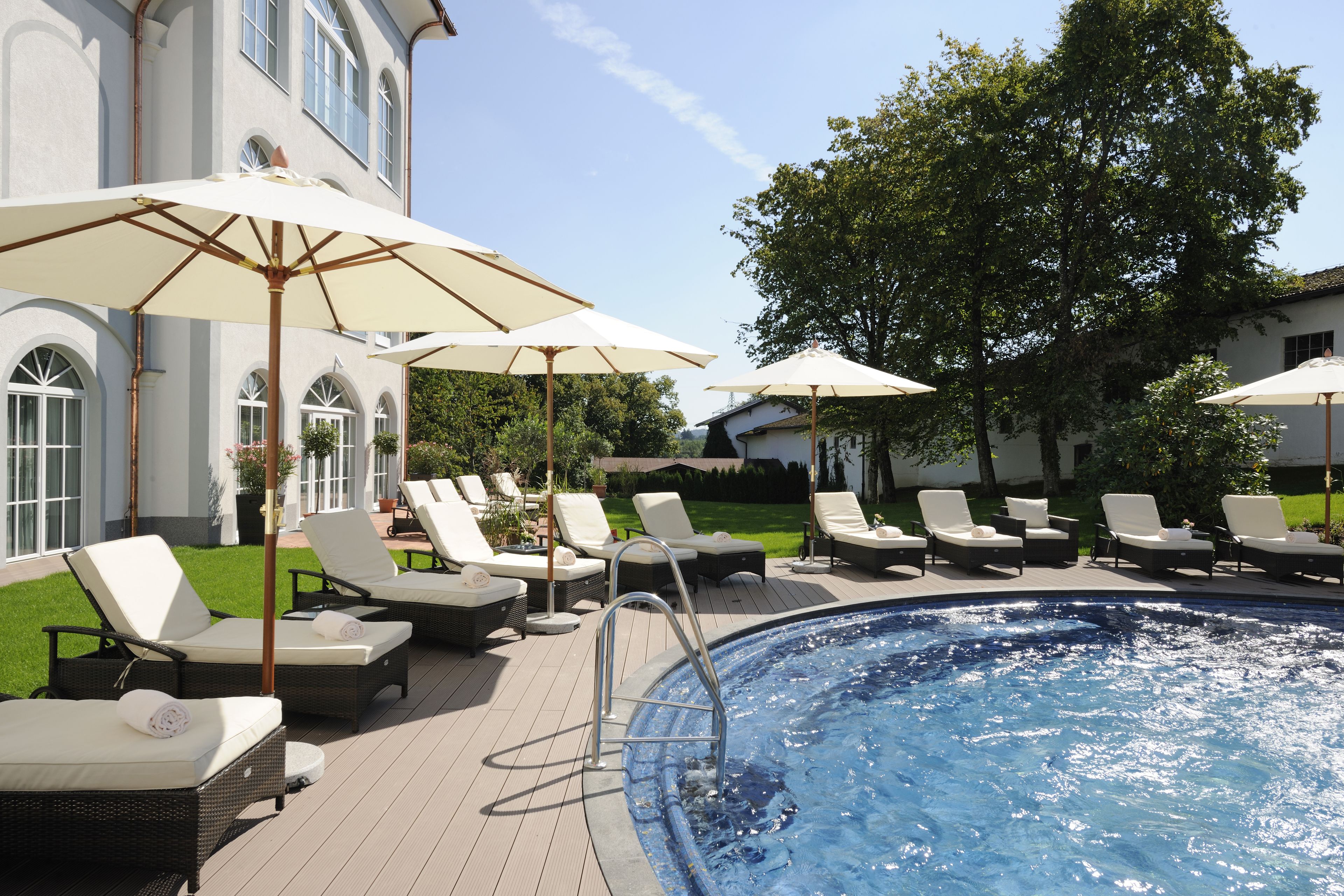 Una piscina techada, una piscina al aire libre, sombrillas