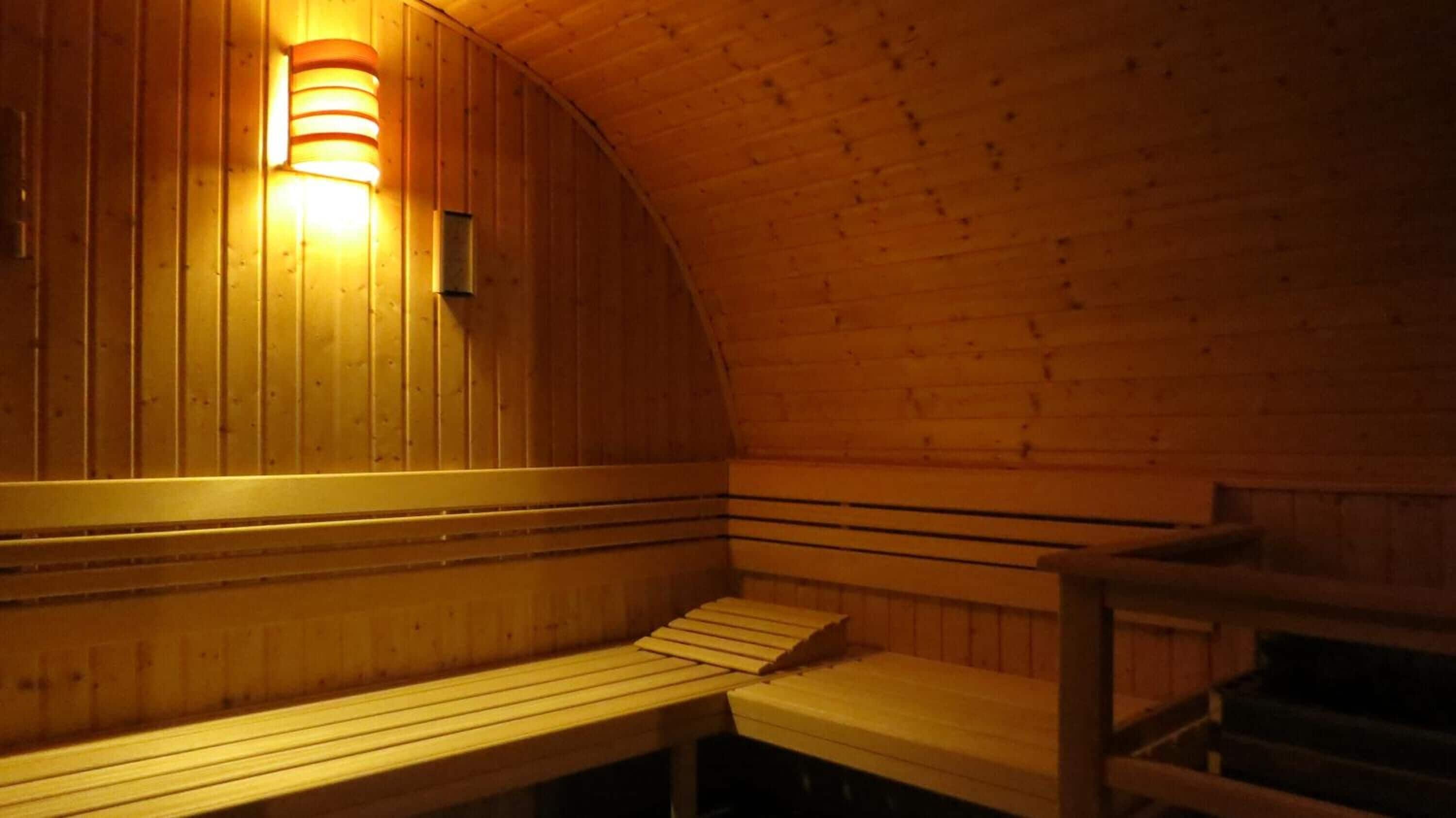Uma sauna com bancos de madeira e teto inclinado.
