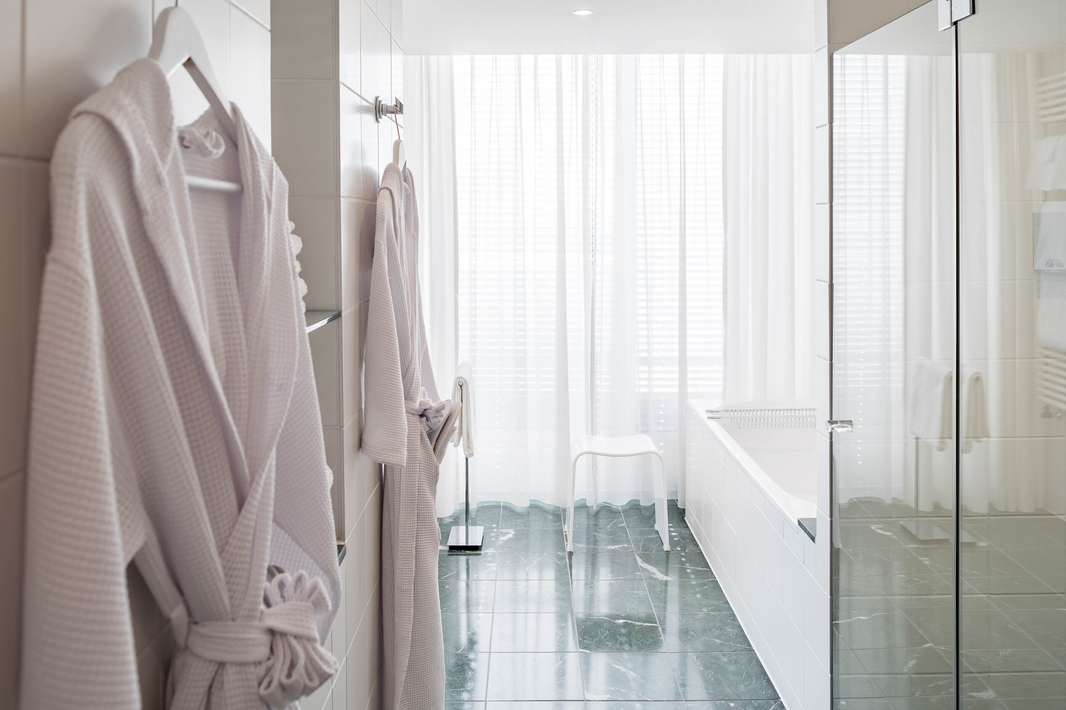 A modern bathroom with a glass shower enclosure, a white bathtub, and a white toilet.