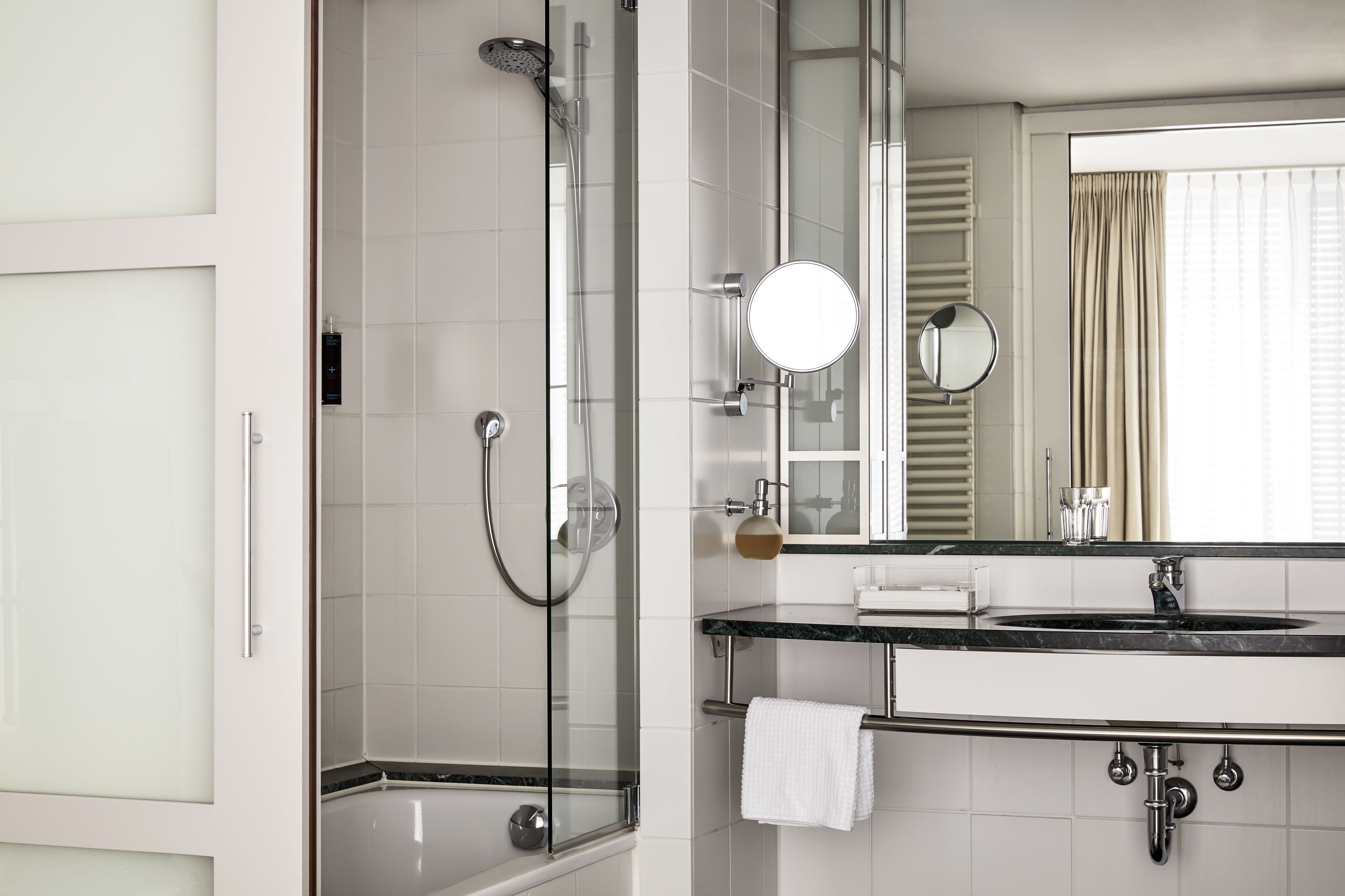 A modern bathroom with a glass-enclosed shower, a vanity with a mirror, and a bathtub.