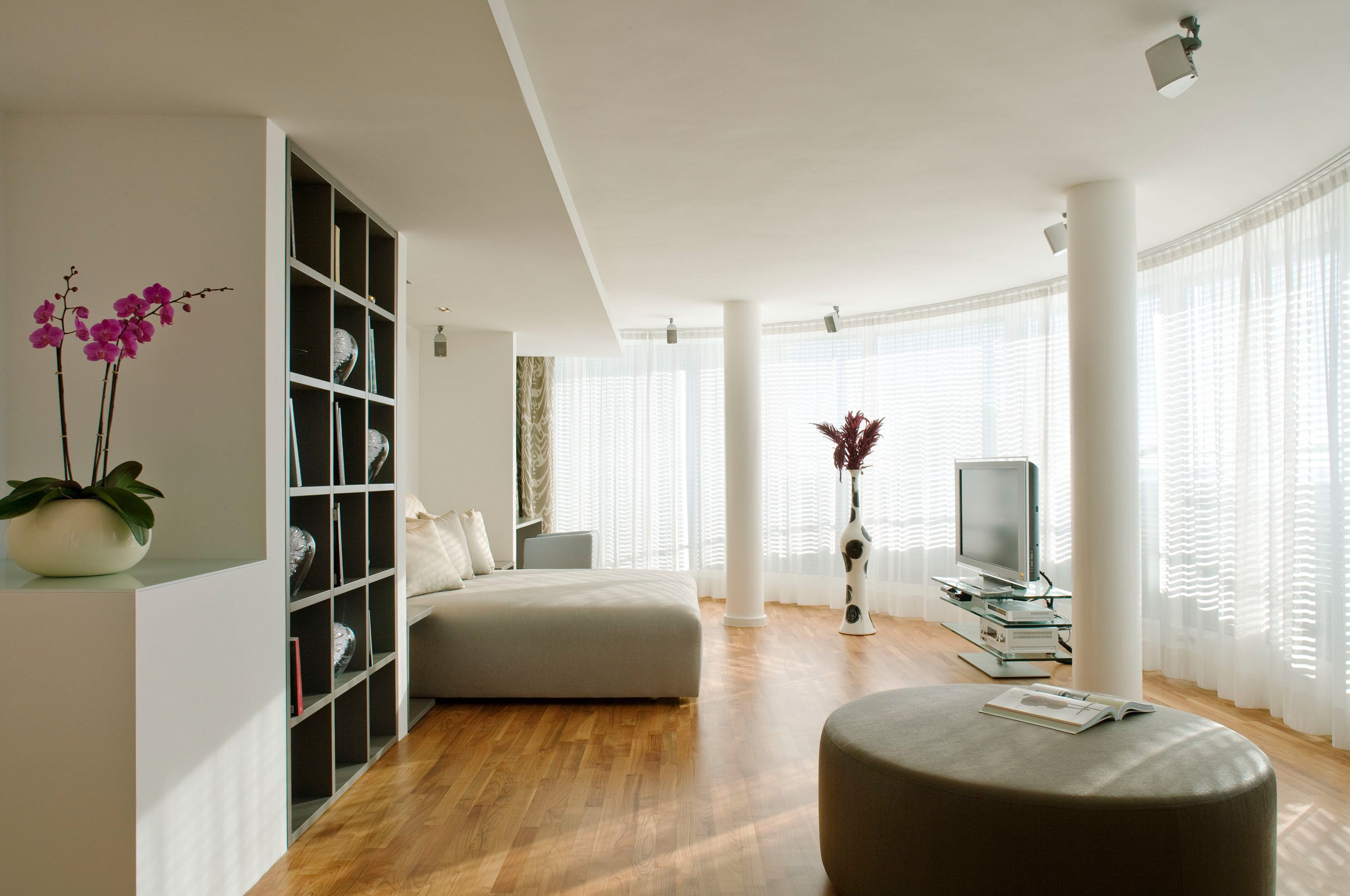 Uma sala de estar moderna com um sofá, uma televisão e uma estante de livros.