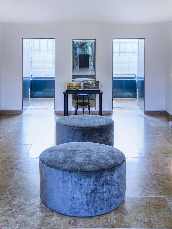 Seating areas and elegant vases line the hallway, leading to a balcony with a view.