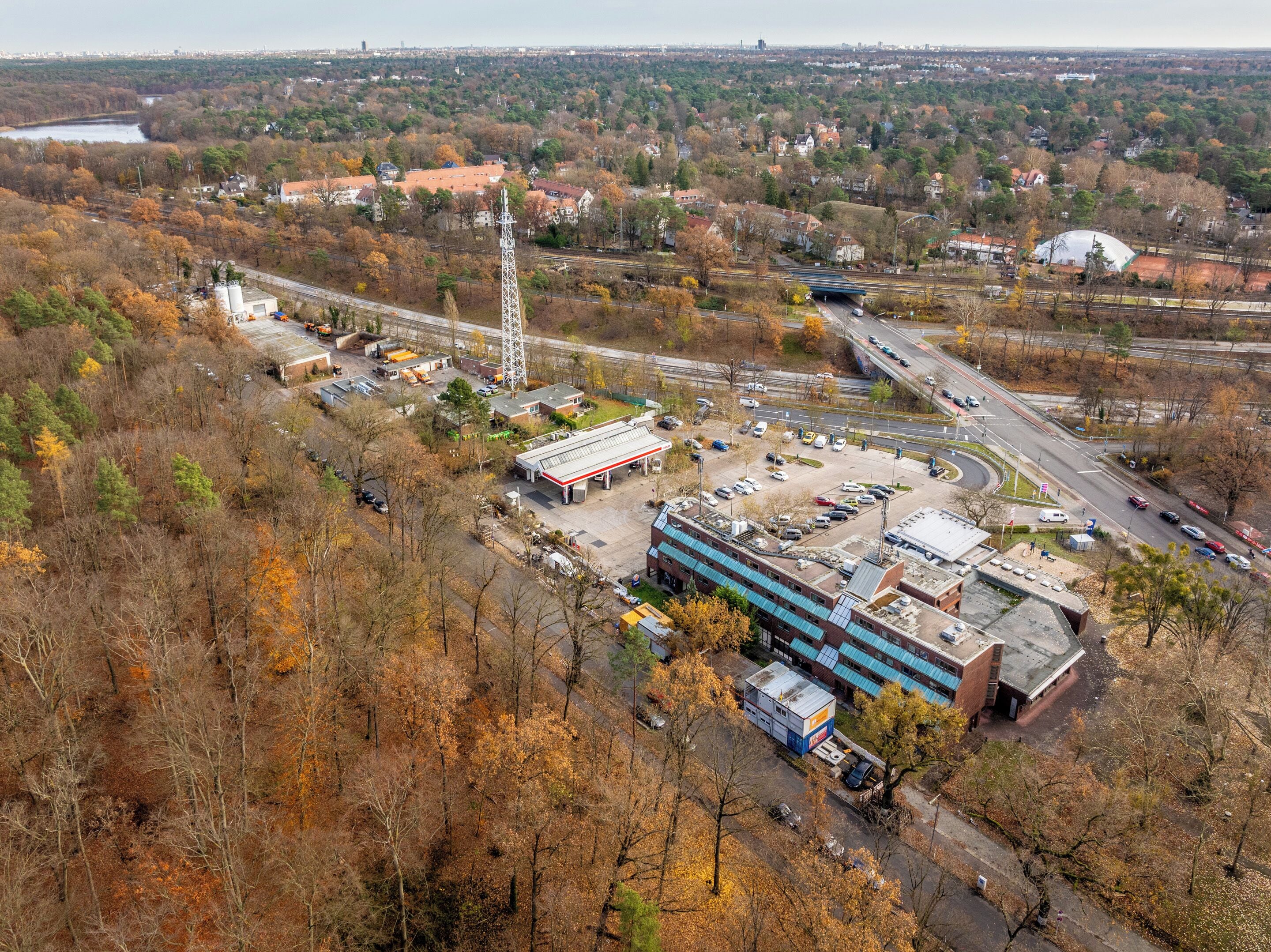 An industrial area with a large building, a gas station, and a highway interchange.