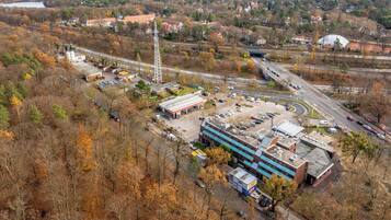 An industrial area with a large building, a gas station, and a highway interchange.