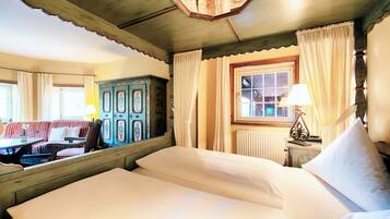 A room with a bed, a window with curtains, a radiator, and a wooden cabinet.