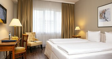 Ropa de cama hipoalergénica y caja de seguridad en la habitación 