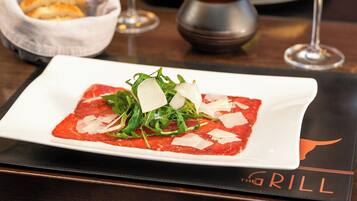 A plate of food on a table with a placemat that reads "The Grill".