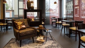 A modern interior with leather seating, a fireplace, and a view of the street.