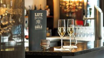 A bar area with a menu stand displaying the text "LIFE BEGINS with a SMILE AND MANY GOOD DRINKS."
