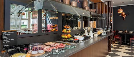 A buffet counter with various food items and a chalkboard menu listing options like 'Kochschinken' and 'Salomi'.