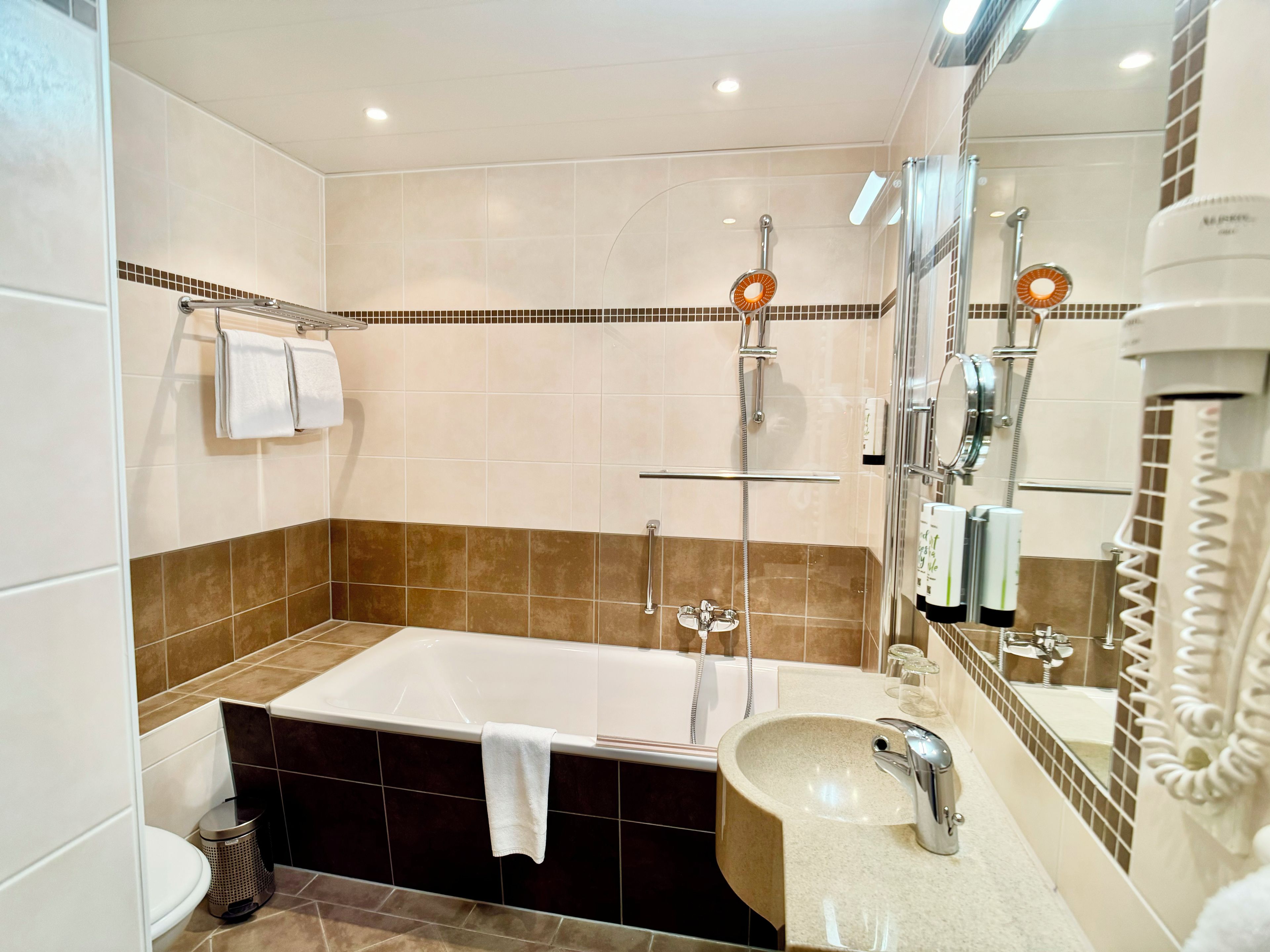 Ein modernes Badezimmer mit Badewanne, Waschbecken und Dusche.