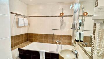 Ein modernes Badezimmer mit Badewanne, Waschbecken und Dusche.