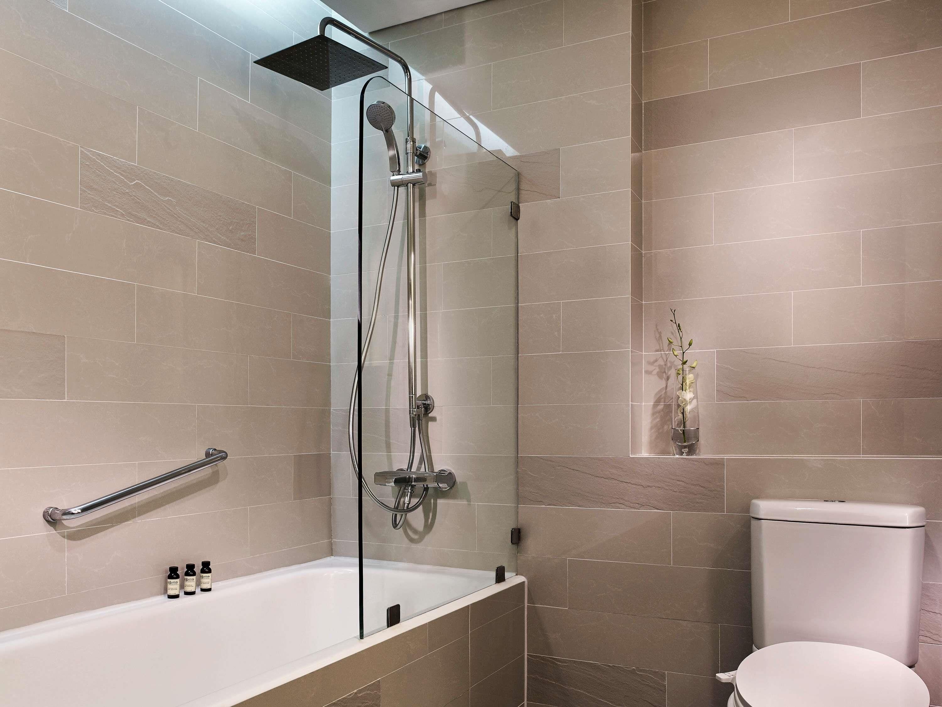 Une salle de bain moderne équipée d’une douche, de toilettes et d’une baignoire.