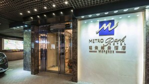 The entrance of the Metro Park Hotel with a glass door, a visible interior, and a sign with the hotel's name. - Metropark Hotel Mongkok (Kowloon)