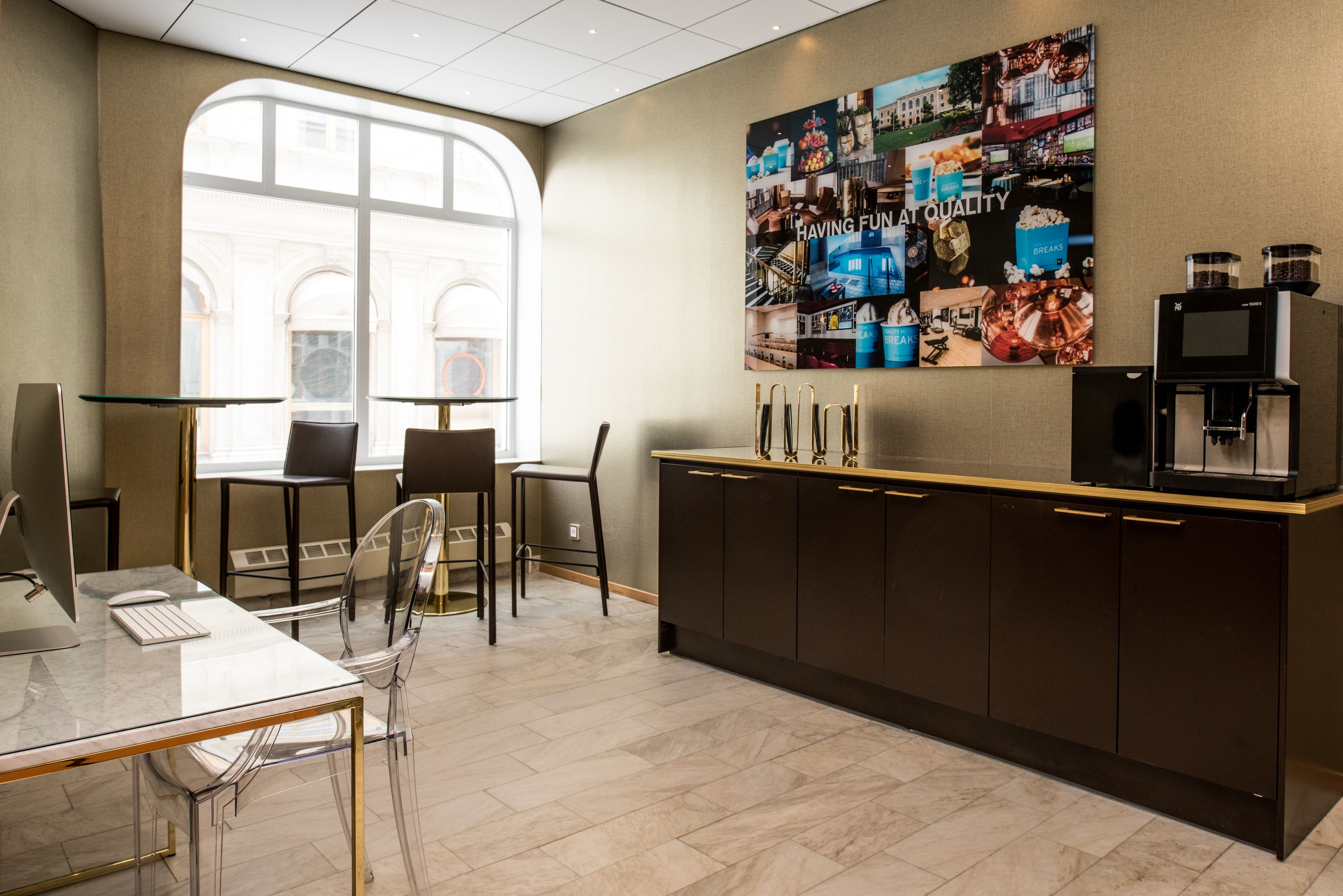 A modern kitchen with a large window, a coffee machine, and a wall art piece.