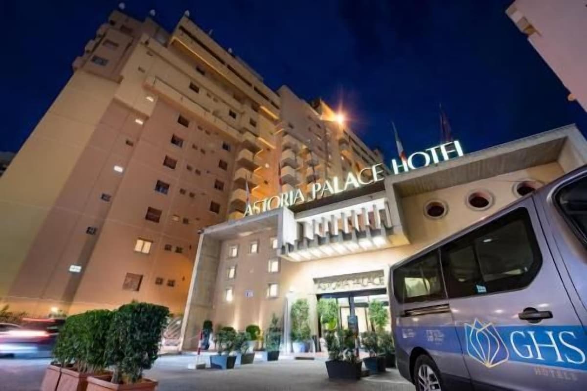 A hotel entrance with a sign reading 'Victoria Palace Hotel.'
