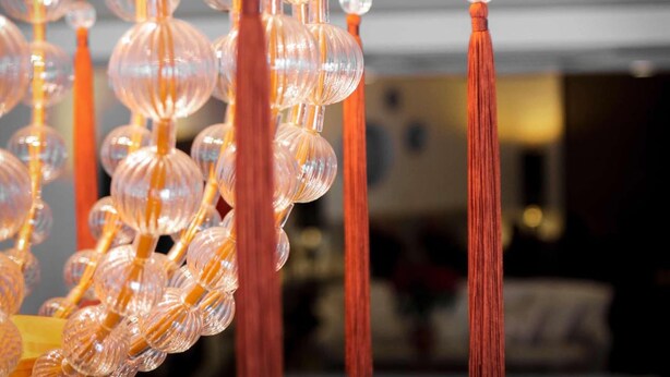 A close-up of clear glass orbs and red tassels hanging from a structure. - Hotel Caravel (Rome)