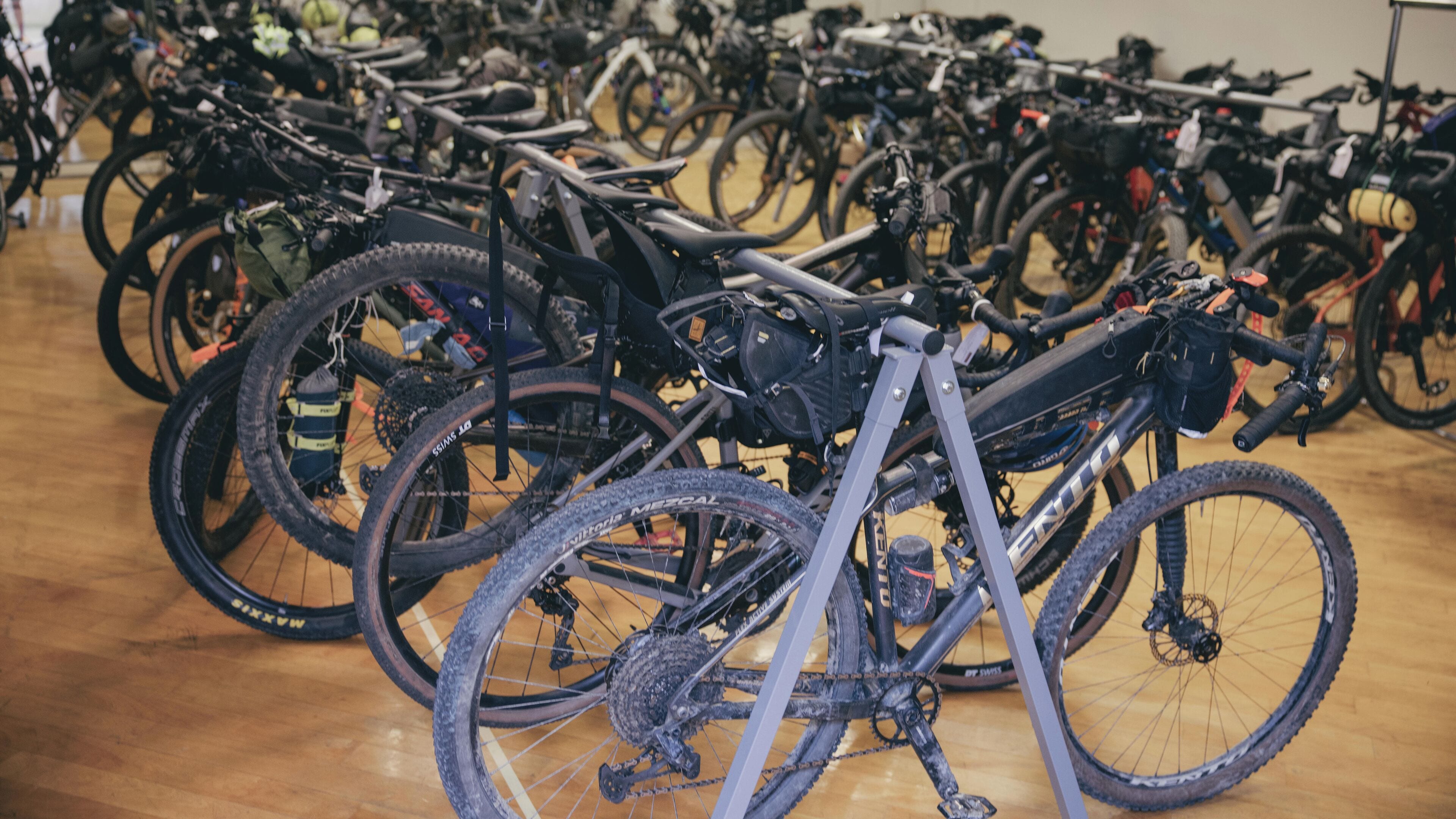 Un amplio espacio interior con filas de bicicletas estacionadas contra la pared.
