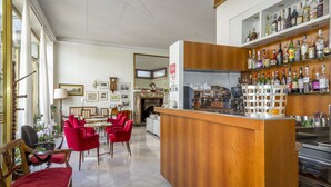 A spacious living area with a wooden bar, red chairs, and a fireplace. - Albergo Ristorante Tre Re (Como)