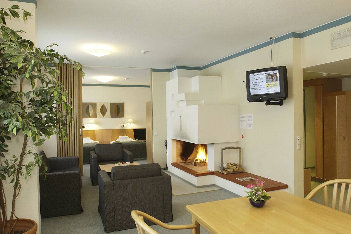 A cozy room with a fireplace, a television, and a dining area with a table and chairs.