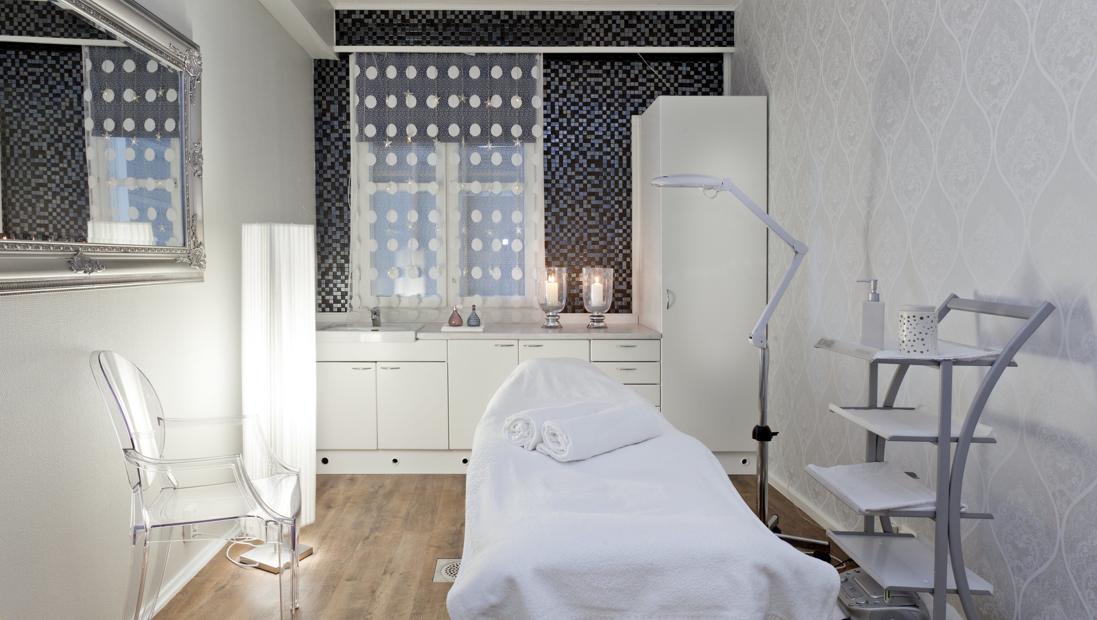 Un baño moderno con cama, tocador con espejo, lavamanos y zona de ducha.