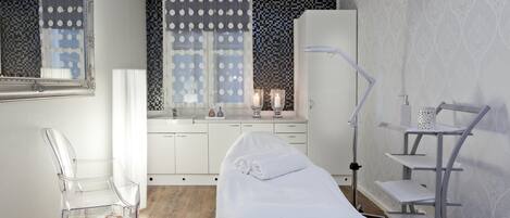 Un baño moderno con cama, tocador con espejo, lavamanos y zona de ducha.