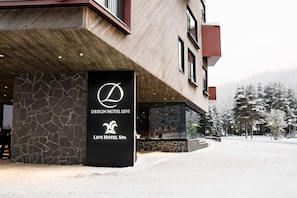 The exterior of Design Hotel Levi with a stone facade and a large glass entrance.