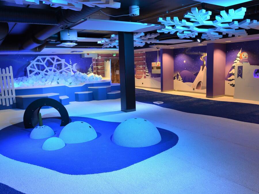 An indoor play area with snow-like structures and a starry night theme.