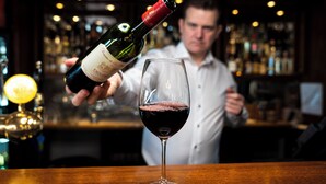 A bar setting with a bottle being poured into a glass.