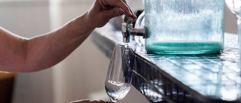 A hand filling a glass from a tap.