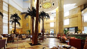 A spacious lobby with high ceilings, palm trees, and a central reception area. - Ningbo Nanyuan Hotel (Ningbo)