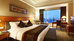 A hotel room with a large bed, a desk, a chair, and a television. - Ningbo Nanyuan Hotel (Ningbo)