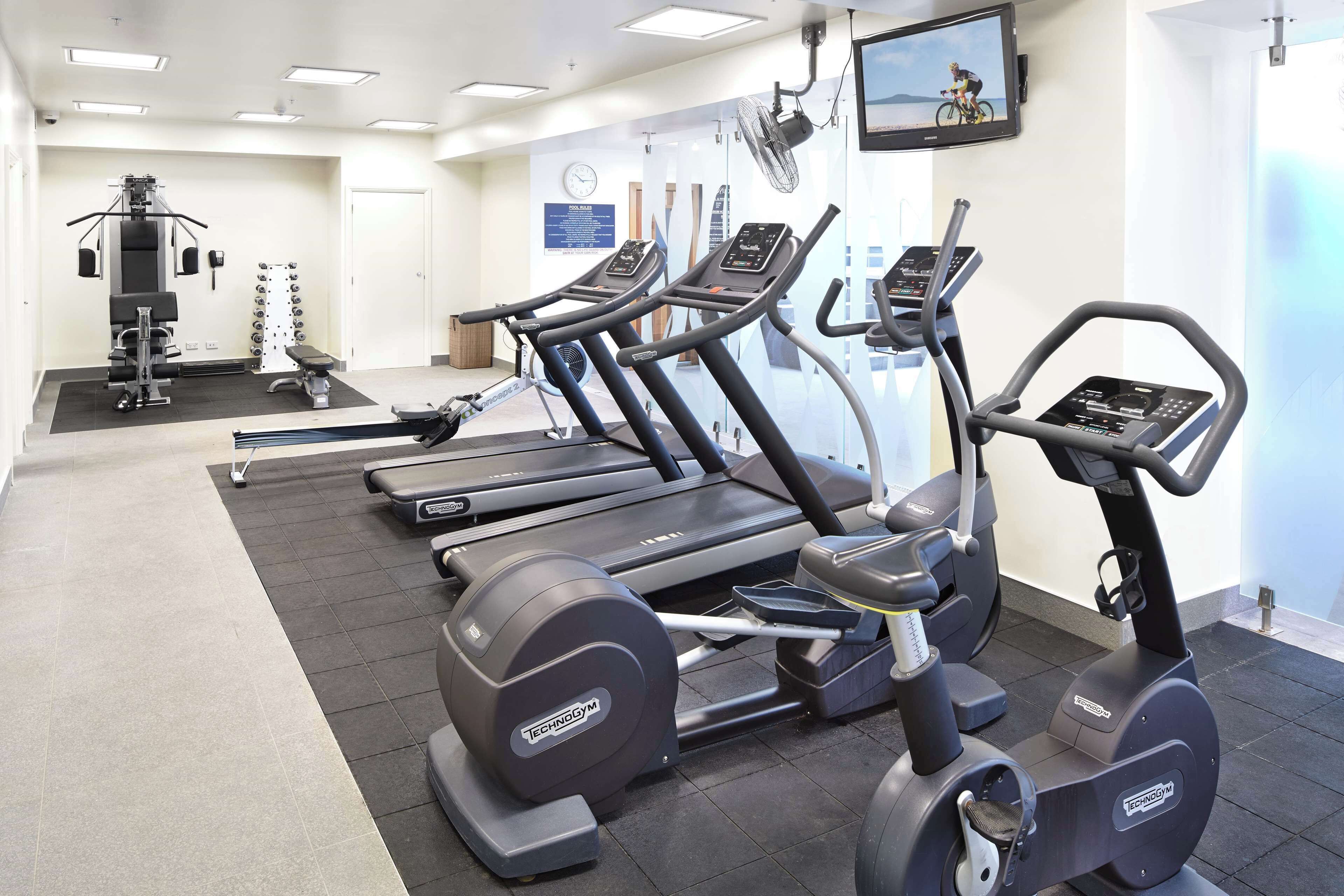 A gym with treadmills, elliptical machines, and weight equipment.