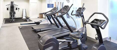 A gym with treadmills, elliptical machines, and weight equipment.