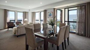 Una habitación de hotel amplia con balcón, comedor y sala de estar.
