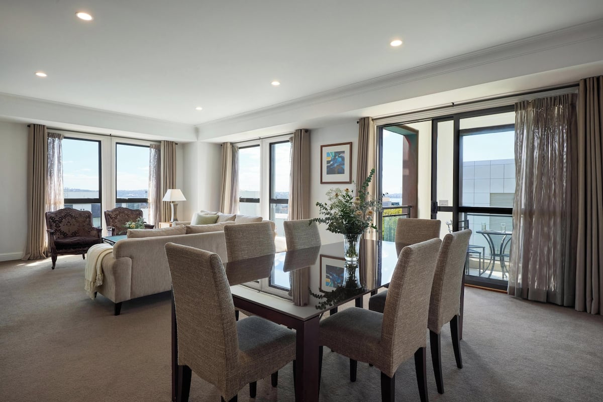 Une chambre d’hôtel spacieuse dotée d’un balcon, d’un coin repas et d’un espace salon.