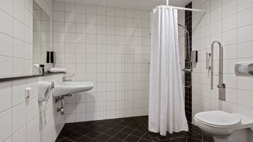 Un bagno moderno con lavandino, water e doccia bianchi.