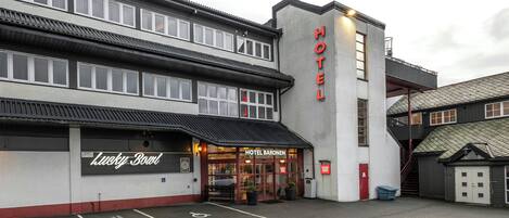A hotel with a sign reading 'HOTEL BARONEN' and a 'Lucky Bow' sign below.