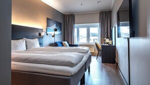 A hotel room with a large bed, a desk, a chair, a TV, and a painting on the wall. - Thon Hotel Baronen (Ålesund)